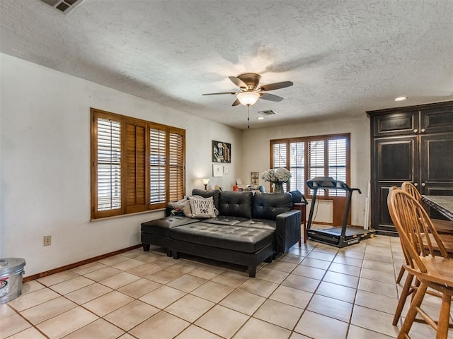 tiled living room featuring ceiling fan and a textured ceiling