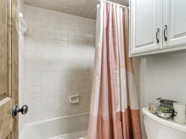 bathroom featuring toilet and shower / bath combination with curtain