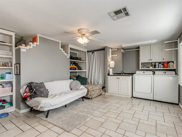 washroom with ceiling fan, cabinets, separate washer and dryer, and sink