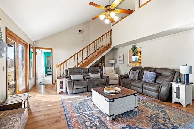 living room with ceiling fan, high vaulted ceiling, and light wood-type flooring