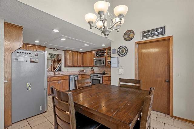 tiled dining area featuring a textured ceiling and a notable chandelier