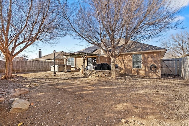 back of property with a patio area and a hot tub