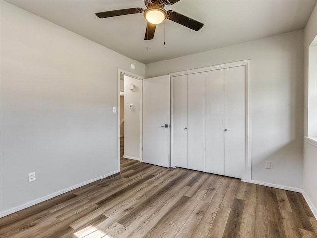 unfurnished bedroom with ceiling fan, a closet, and hardwood / wood-style floors