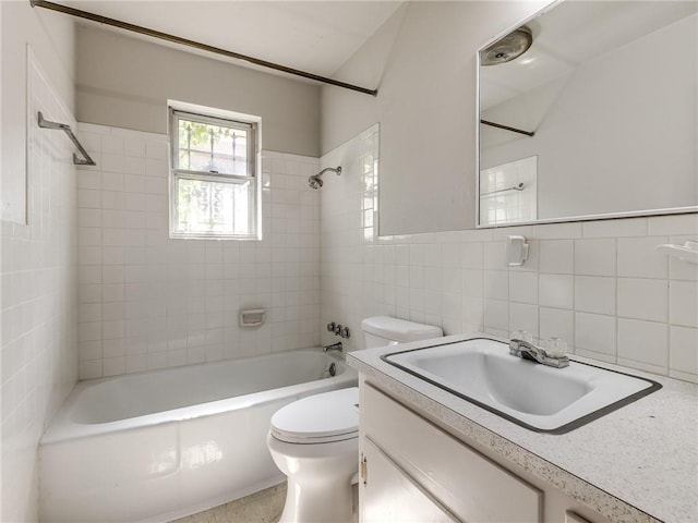 full bathroom with toilet, vanity, tile walls, and tiled shower / bath combo