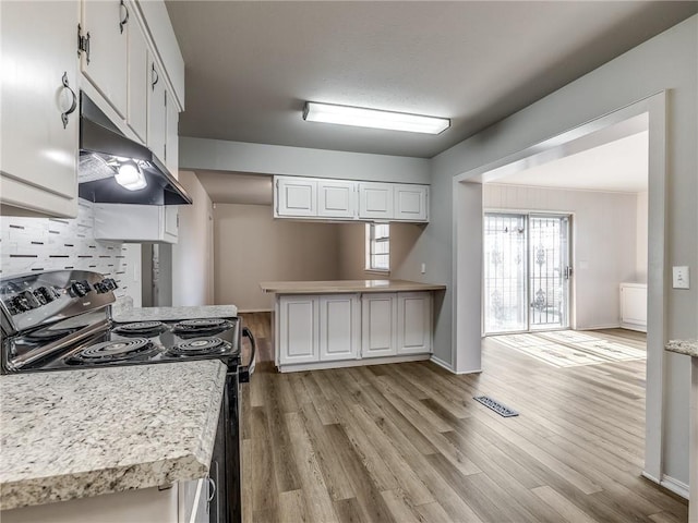 kitchen with black / electric stove, backsplash, white cabinetry, and light hardwood / wood-style floors