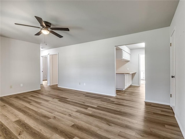 spare room with light wood-type flooring and ceiling fan