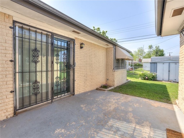 entrance to property with a lawn and a patio