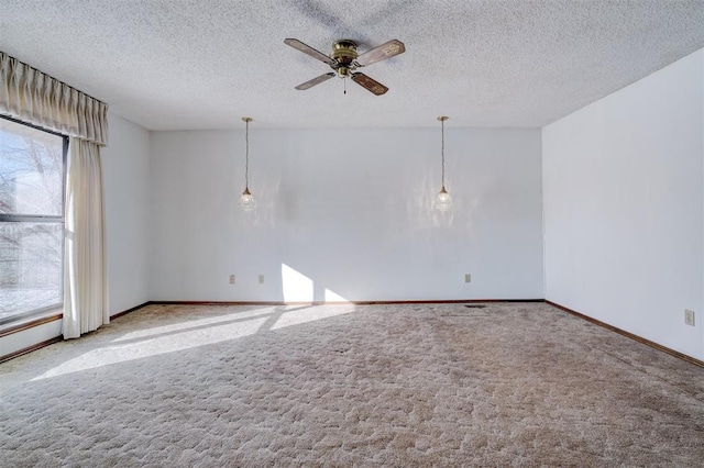 carpeted spare room featuring ceiling fan and a textured ceiling