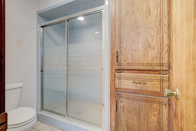 bathroom with tile patterned flooring, toilet, and walk in shower