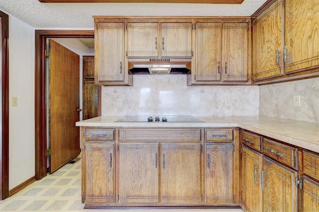 kitchen with black electric stovetop, decorative backsplash, and a textured ceiling