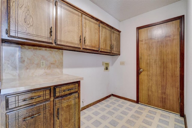 laundry area featuring cabinets, washer hookup, and a textured ceiling