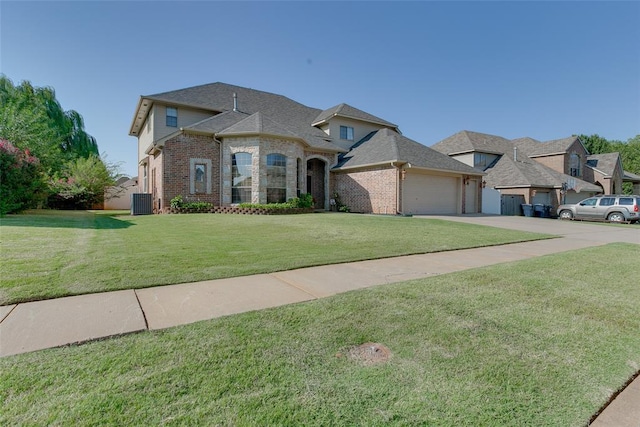 french provincial home featuring a front lawn, a garage, and central air condition unit