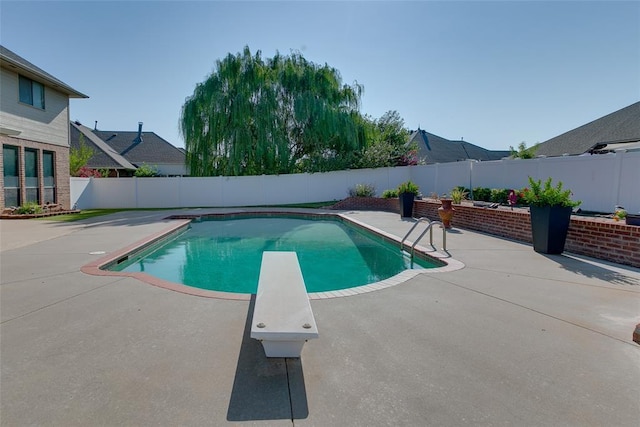 view of pool featuring a diving board and a patio