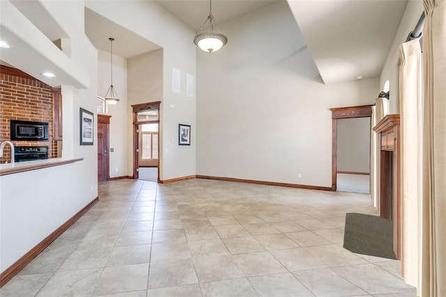 interior space featuring light tile patterned floors, a high ceiling, and sink