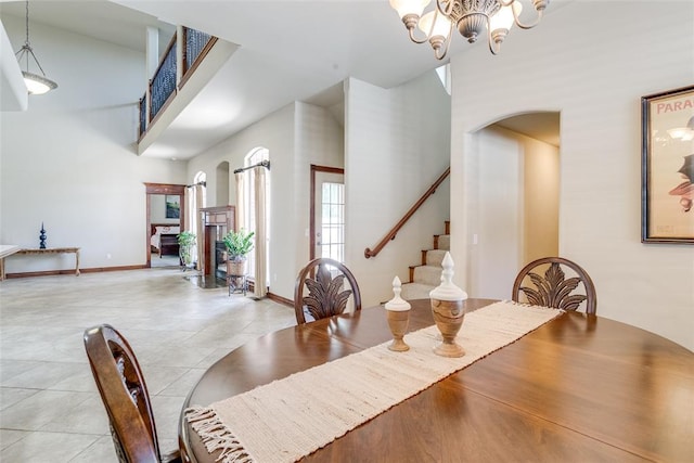 dining area with a towering ceiling and an inviting chandelier