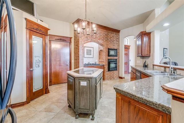 kitchen featuring decorative light fixtures, a kitchen island, sink, an inviting chandelier, and black oven