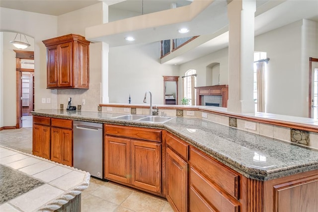 kitchen with dishwasher, a center island, sink, backsplash, and light tile patterned floors