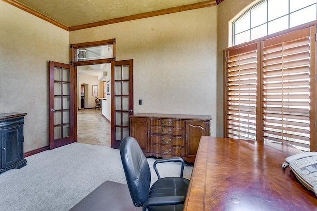 home office with light carpet, french doors, and crown molding