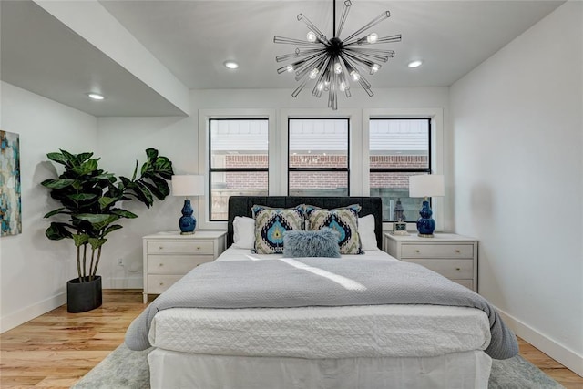 bedroom featuring light wood-type flooring and a chandelier