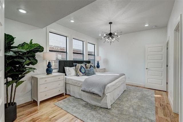 bedroom with a notable chandelier and light hardwood / wood-style flooring