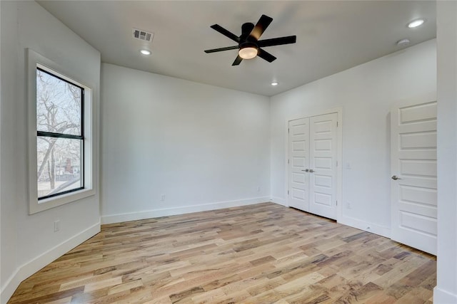 unfurnished bedroom with ceiling fan, light wood-type flooring, and multiple windows