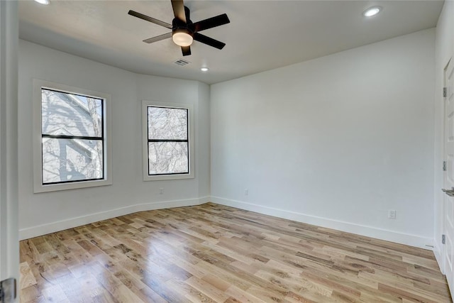 empty room with ceiling fan and light hardwood / wood-style floors