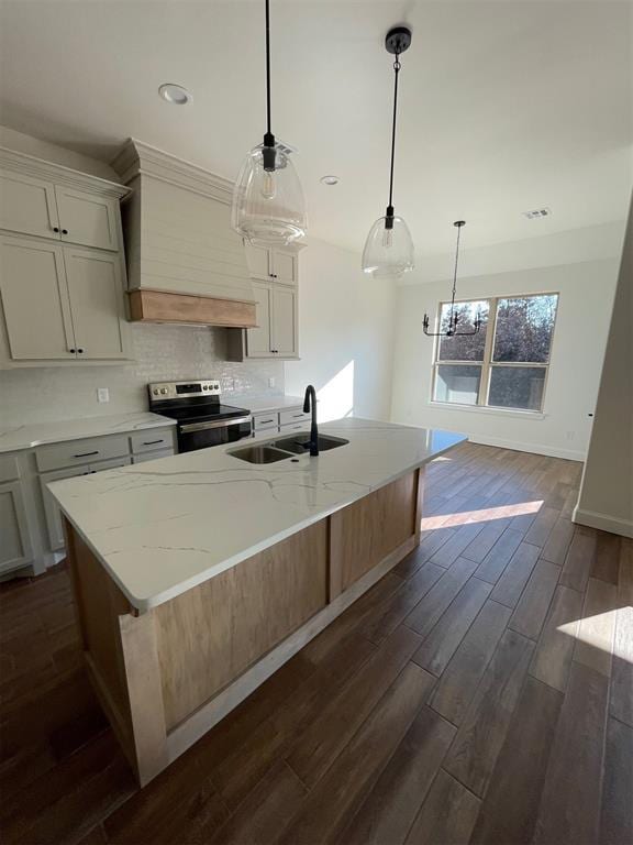 kitchen with sink, electric range, premium range hood, and an island with sink