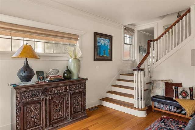 stairs featuring hardwood / wood-style flooring and crown molding