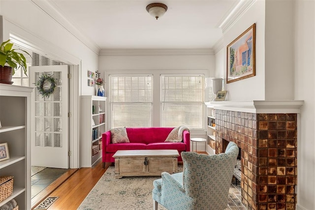 sitting room with crown molding, wood-type flooring, and a fireplace