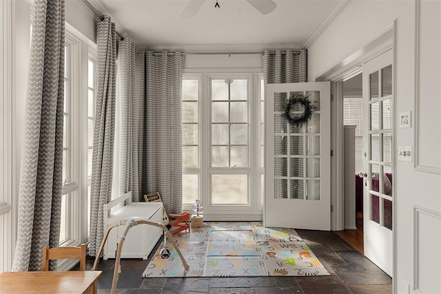 doorway with crown molding, ceiling fan, and a wealth of natural light