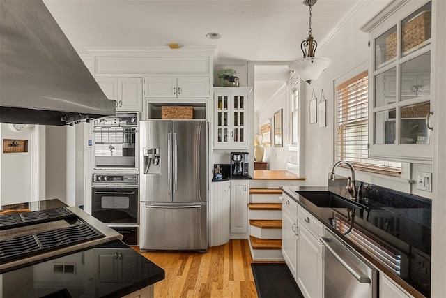 kitchen with pendant lighting, island range hood, white cabinetry, sink, and stainless steel fridge with ice dispenser