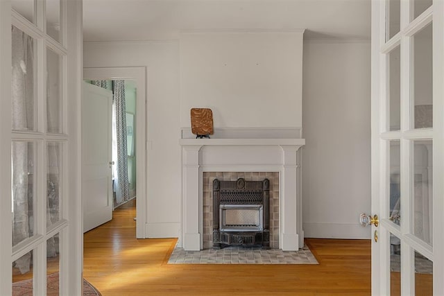 unfurnished living room with crown molding, wood-type flooring, and french doors