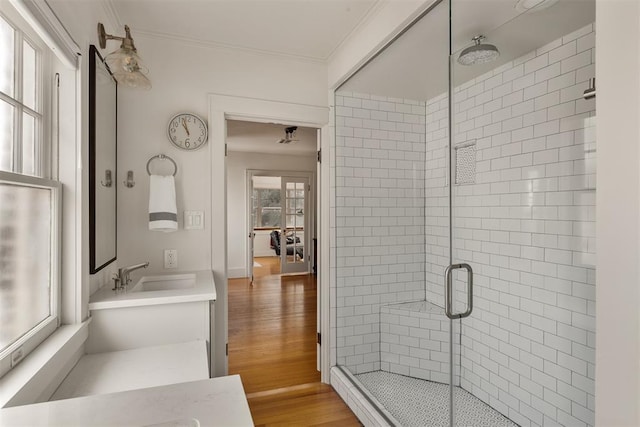 bathroom featuring ornamental molding, hardwood / wood-style floors, vanity, and a shower with shower door