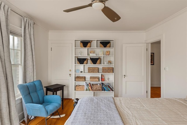 bedroom featuring hardwood / wood-style flooring, crown molding, and ceiling fan