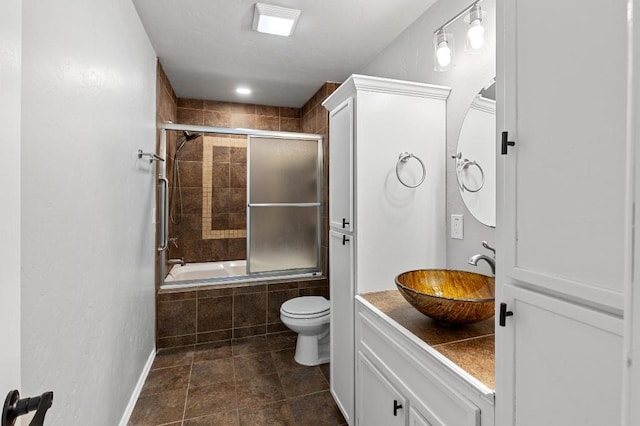 full bathroom with toilet, combined bath / shower with glass door, and vanity