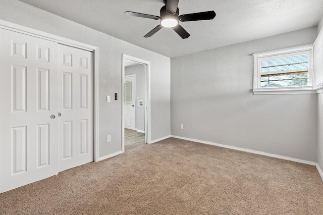 unfurnished bedroom featuring ceiling fan, a closet, and carpet floors