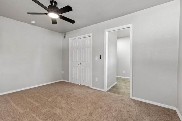 unfurnished bedroom featuring ceiling fan, light colored carpet, and a closet