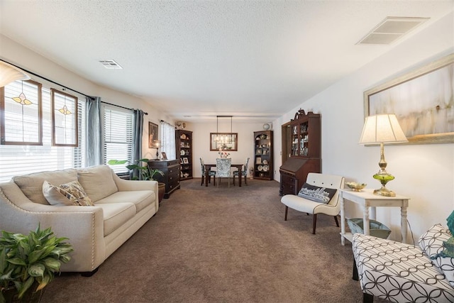 living room featuring a textured ceiling and dark carpet