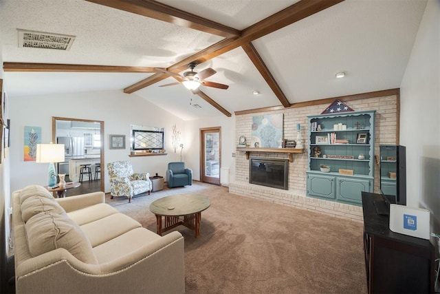 carpeted living room with a fireplace, a textured ceiling, vaulted ceiling with beams, and ceiling fan