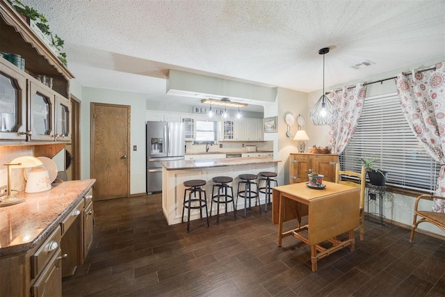 dining room with a textured ceiling and dark hardwood / wood-style floors