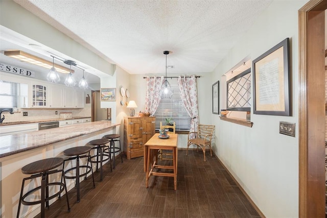 dining room featuring sink and a textured ceiling