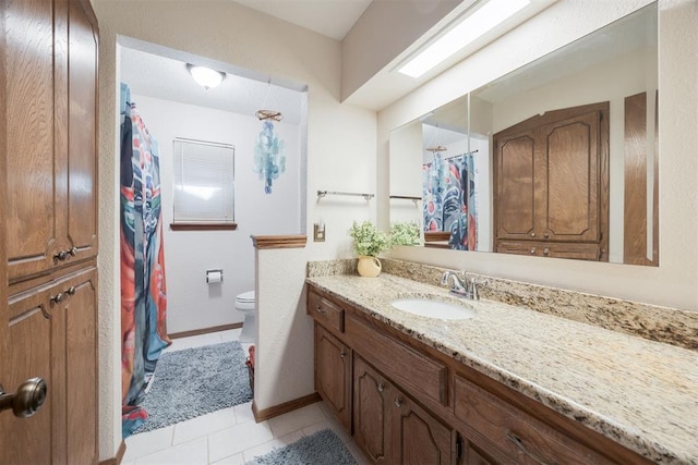 bathroom with tile patterned floors, vanity, a skylight, and toilet