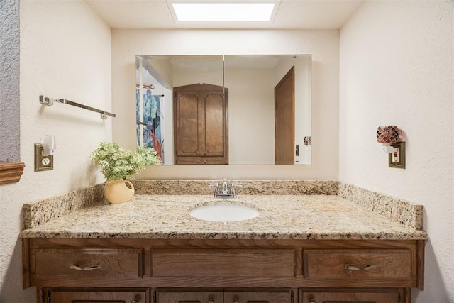 bathroom featuring vanity and a skylight