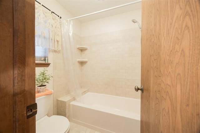 bathroom featuring toilet, shower / bath combo with shower curtain, and tile patterned flooring