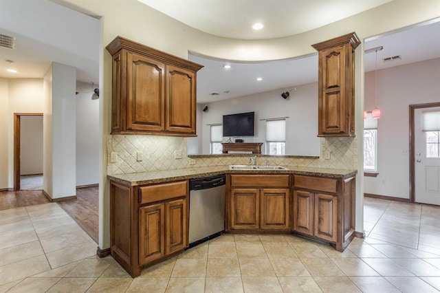 kitchen featuring sink, light tile patterned floors, stone counters, tasteful backsplash, and stainless steel dishwasher