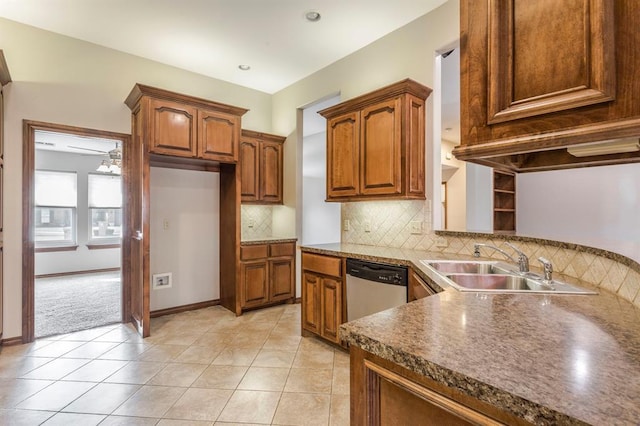 kitchen with light tile patterned flooring, stainless steel dishwasher, sink, and backsplash