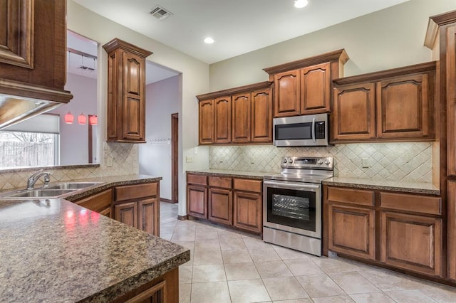 kitchen featuring sink, light tile patterned floors, stainless steel appliances, and backsplash