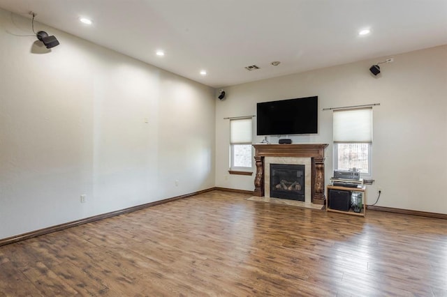 unfurnished living room featuring a premium fireplace and hardwood / wood-style floors