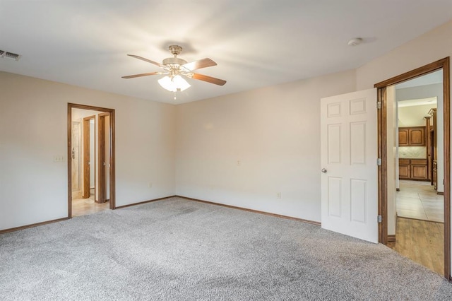 carpeted spare room featuring ceiling fan