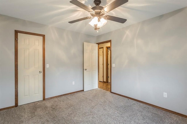 carpeted spare room with ceiling fan